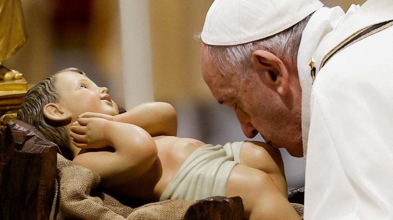 Pope Francis kisses a statue of baby Jesus as he celebrates Christmas Eve Holy Mass in St. Peter's Basilica at the Vatican, December 24, 2021. REUTERS/Guglielmo Mangiapane     TPX IMAGES OF THE DAY