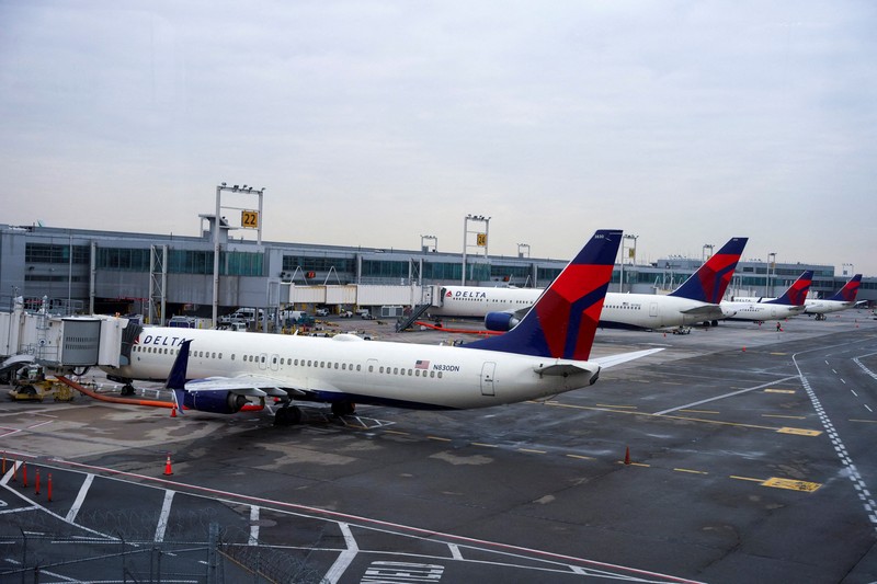 Passengers line up at John F. Kennedy International Airport after airlines announced numerous flights were canceled during the spread of the Omicron coronavirus variant on Christmas Eve in Queens, New York City, U.S., December 24, 2021. REUTERS/Dieu-Nalio Chery REFILE - QUALITY REPEAT