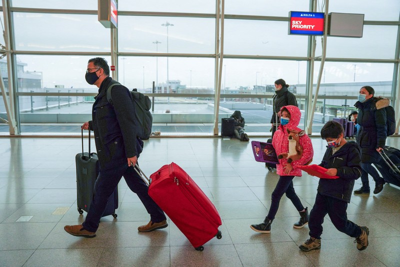 Passengers line up at John F. Kennedy International Airport after airlines announced numerous flights were canceled during the spread of the Omicron coronavirus variant on Christmas Eve in Queens, New York City, U.S., December 24, 2021. REUTERS/Dieu-Nalio Chery REFILE - QUALITY REPEAT