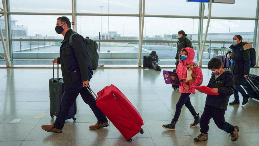 Passengers line up at John F. Kennedy International Airport after airlines announced numerous flights were canceled during the spread of the Omicron coronavirus variant on Christmas Eve in Queens, New York City, U.S., December 24, 2021. REUTERS/Dieu-Nalio Chery REFILE - QUALITY REPEAT