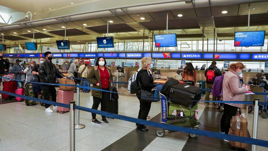Passengers line up at John F. Kennedy International Airport after airlines announced numerous flights were canceled during the spread of the Omicron coronavirus variant on Christmas Eve in Queens, New York City, U.S., December 24, 2021. REUTERS/Dieu-Nalio Chery REFILE - QUALITY REPEAT