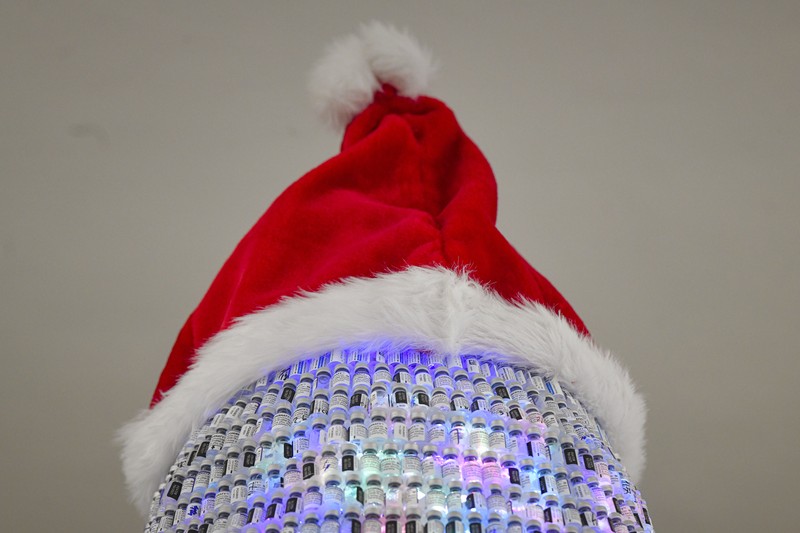 Virus Outbreak Romania LEDs shine inside a Christmas tree made of empty vaccine containers at a vaccination center in Bucharest, Romania, Monday, Dec. 6, 2021. Staff at one of the largest COVID-19 vaccination centers in Bucharest, Romania, have built a three meter tall Christmas tree out of 19 thousand empty vaccine COVID-19 containers, some with colored LEDs placed inside them, they collected since March 2021 for the project. (AP Photo/Andreea Alexandru)