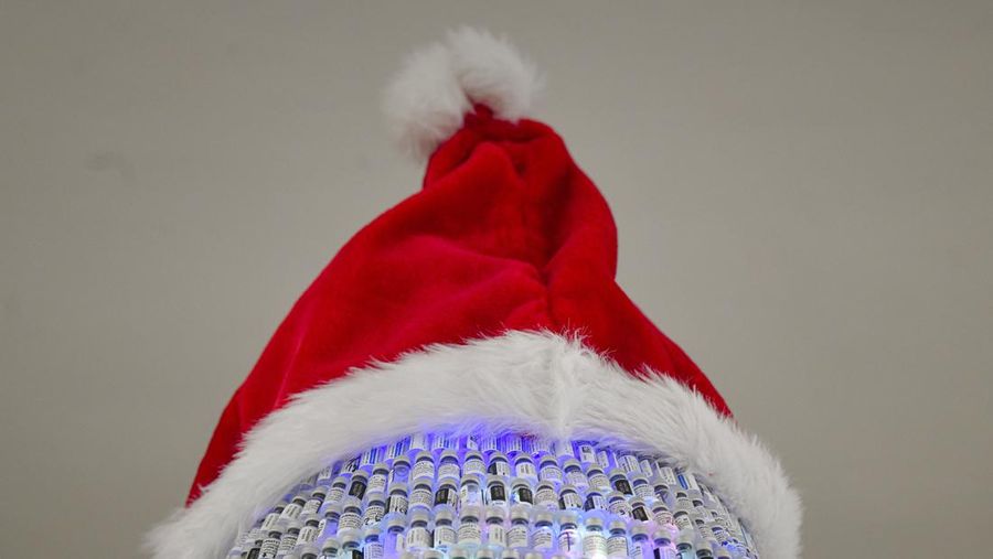 LEDs shine inside a Christmas tree made of empty vaccine containers at a vaccination center in Bucharest, Romania, Monday, Dec. 6, 2021. Staff at one of the largest COVID-19 vaccination centers in Bucharest, Romania, have built a three meter tall Christmas tree out of 19 thousand empty vaccine COVID-19 containers, some with colored LEDs placed inside them, they collected since March 2021 for the project. (AP Photo/Andreea Alexandru)