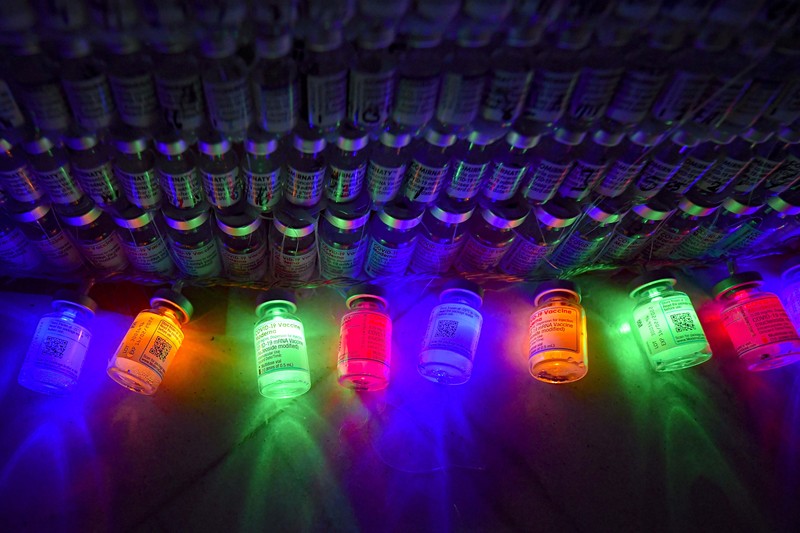 LEDs shine inside a Christmas tree made of empty vaccine containers at a vaccination center in Bucharest, Romania, Monday, Dec. 6, 2021. Staff at one of the largest COVID-19 vaccination centers in Bucharest, Romania, have built a three meter tall Christmas tree out of 19 thousand empty vaccine COVID-19 containers, some with colored LEDs placed inside them, they collected since March 2021 for the project. (AP Photo/Andreea Alexandru)
