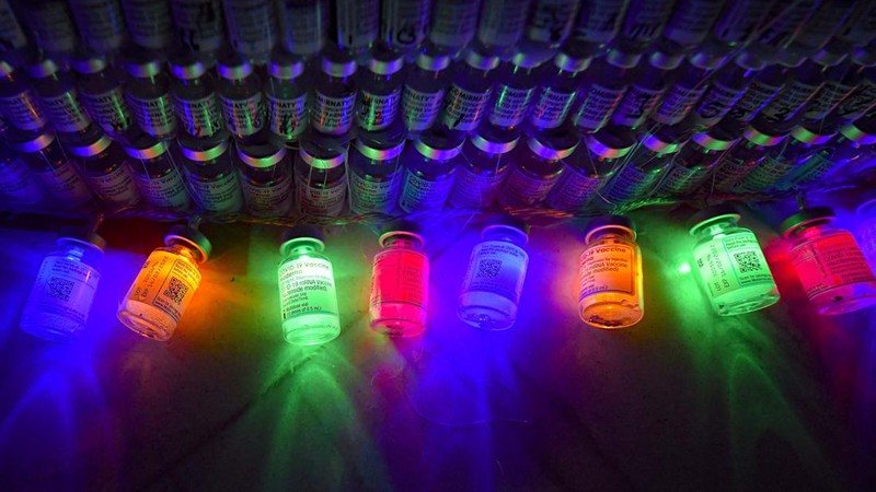 LEDs shine inside a Christmas tree made of empty vaccine containers at a vaccination center in Bucharest, Romania, Monday, Dec. 6, 2021. Staff at one of the largest COVID-19 vaccination centers in Bucharest, Romania, have built a three meter tall Christmas tree out of 19 thousand empty vaccine COVID-19 containers, some with colored LEDs placed inside them, they collected since March 2021 for the project. (AP Photo/Andreea Alexandru)