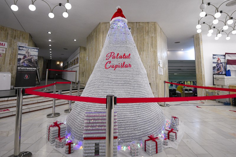 LEDs shine inside a Christmas tree made of empty vaccine containers at a vaccination center in Bucharest, Romania, Monday, Dec. 6, 2021. Staff at one of the largest COVID-19 vaccination centers in Bucharest, Romania, have built a three meter tall Christmas tree out of 19 thousand empty vaccine COVID-19 containers, some with colored LEDs placed inside them, they collected since March 2021 for the project. (AP Photo/Andreea Alexandru)