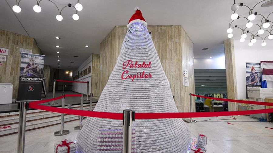 LEDs shine inside a Christmas tree made of empty vaccine containers at a vaccination center in Bucharest, Romania, Monday, Dec. 6, 2021. Staff at one of the largest COVID-19 vaccination centers in Bucharest, Romania, have built a three meter tall Christmas tree out of 19 thousand empty vaccine COVID-19 containers, some with colored LEDs placed inside them, they collected since March 2021 for the project. (AP Photo/Andreea Alexandru)