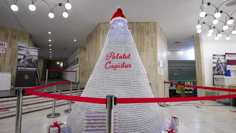 LEDs shine inside a Christmas tree made of empty vaccine containers at a vaccination center in Bucharest, Romania, Monday, Dec. 6, 2021. Staff at one of the largest COVID-19 vaccination centers in Bucharest, Romania, have built a three meter tall Christmas tree out of 19 thousand empty vaccine COVID-19 containers, some with colored LEDs placed inside them, they collected since March 2021 for the project. (AP Photo/Andreea Alexandru)