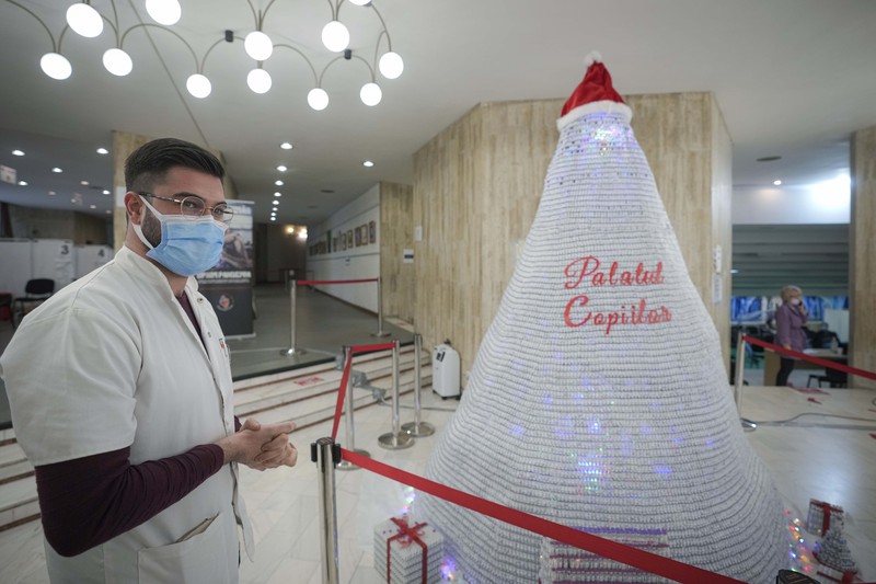 LEDs shine inside a Christmas tree made of empty vaccine containers at a vaccination center in Bucharest, Romania, Monday, Dec. 6, 2021. Staff at one of the largest COVID-19 vaccination centers in Bucharest, Romania, have built a three meter tall Christmas tree out of 19 thousand empty vaccine COVID-19 containers, some with colored LEDs placed inside them, they collected since March 2021 for the project. (AP Photo/Andreea Alexandru)
