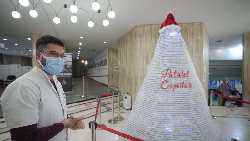LEDs shine inside a Christmas tree made of empty vaccine containers at a vaccination center in Bucharest, Romania, Monday, Dec. 6, 2021. Staff at one of the largest COVID-19 vaccination centers in Bucharest, Romania, have built a three meter tall Christmas tree out of 19 thousand empty vaccine COVID-19 containers, some with colored LEDs placed inside them, they collected since March 2021 for the project. (AP Photo/Andreea Alexandru)