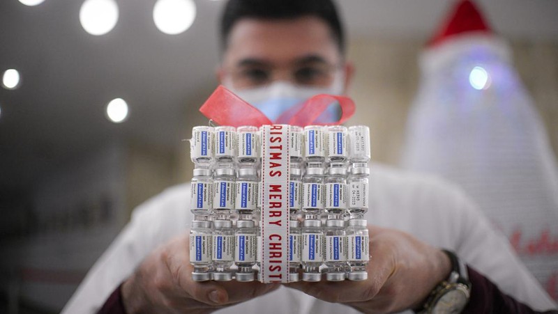 LEDs shine inside a Christmas tree made of empty vaccine containers at a vaccination center in Bucharest, Romania, Monday, Dec. 6, 2021. Staff at one of the largest COVID-19 vaccination centers in Bucharest, Romania, have built a three meter tall Christmas tree out of 19 thousand empty vaccine COVID-19 containers, some with colored LEDs placed inside them, they collected since March 2021 for the project. (AP Photo/Andreea Alexandru)