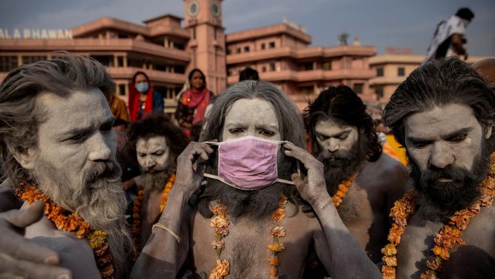 A Naga Sadhu, or Hindu holy man wears a mask before the procession for taking a dip in the Ganges river during Shahi Snan at 