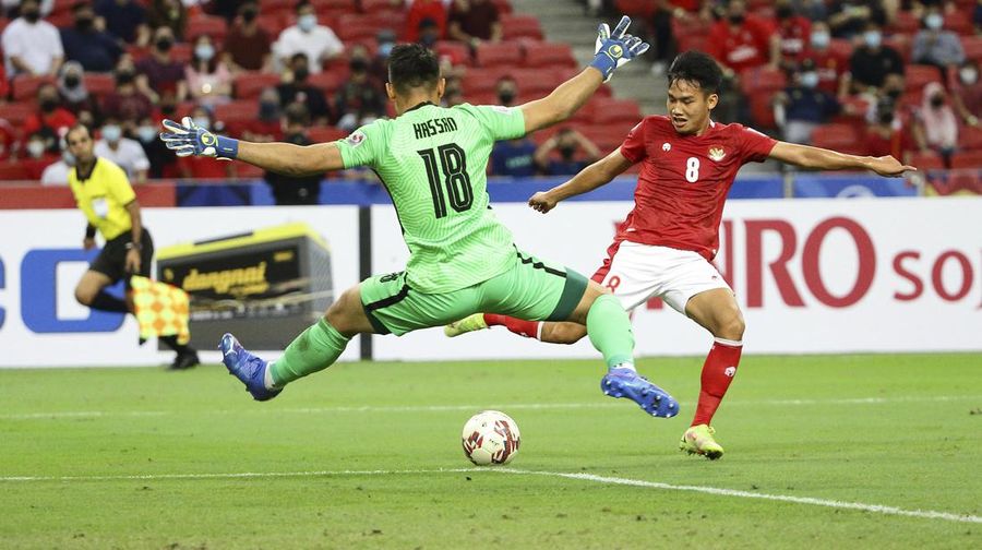 Hassan Sunny of Singapore, foreground, attempts a block on Witan Sulaeman of Indonesia cross during the AFF Suzuki Cup 2020 semi-final second leg match between Indonesia and Singapore in Singapore, Sunday, Dec. 26, 2021. (AP Photo/Suhaimi Abdullah)