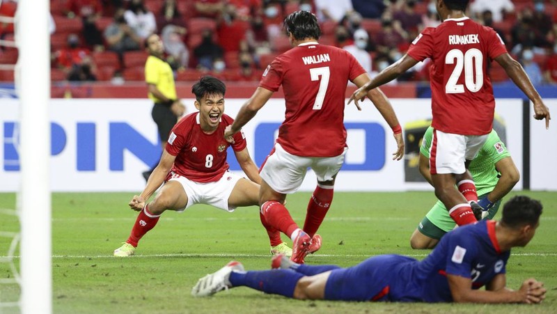 Hassan Sunny of Singapore, foreground, attempts a block on Witan Sulaeman of Indonesia cross during the AFF Suzuki Cup 2020 semi-final second leg match between Indonesia and Singapore in Singapore, Sunday, Dec. 26, 2021. (AP Photo/Suhaimi Abdullah)