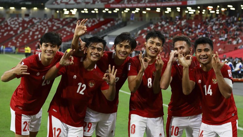 Hassan Sunny of Singapore, foreground, attempts a block on Witan Sulaeman of Indonesia cross during the AFF Suzuki Cup 2020 semi-final second leg match between Indonesia and Singapore in Singapore, Sunday, Dec. 26, 2021. (AP Photo/Suhaimi Abdullah)
