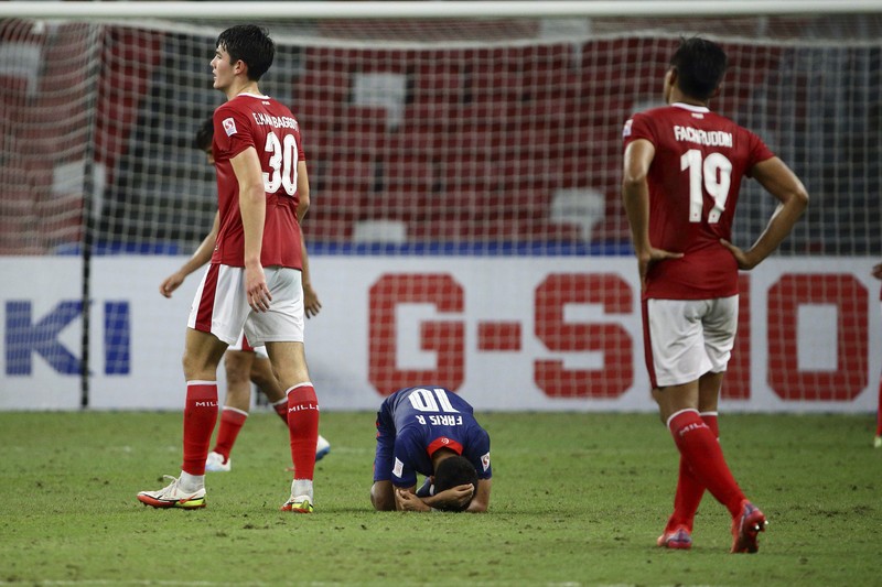 Singapore Soccer Suzuki Cup Hassan Sunny of Singapore, foreground, attempts a block on Witan Sulaeman of Indonesia cross during the AFF Suzuki Cup 2020 semi-final second leg match between Indonesia and Singapore in Singapore, Sunday, Dec. 26, 2021. (AP Photo/Suhaimi Abdullah)