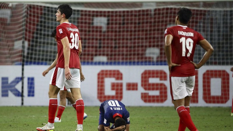 Hassan Sunny of Singapore, foreground, attempts a block on Witan Sulaeman of Indonesia cross during the AFF Suzuki Cup 2020 semi-final second leg match between Indonesia and Singapore in Singapore, Sunday, Dec. 26, 2021. (AP Photo/Suhaimi Abdullah)