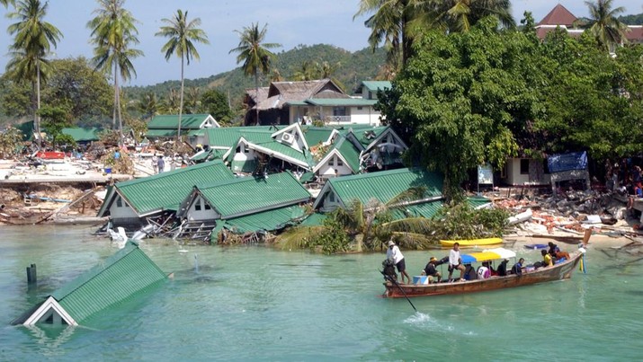 FILE - In this Dec. 28, 2004 file photo, a boat passes by a damaged hotel, at Ton Sai Bay on Phi Phi Island, in Thailand. Friday marks the 10th anniversary of one of the deadliest natural disasters in world history: a tsunami, triggered by a massive earthquake off the Indonesian coast, leaving more than 230,000 people dead in 14 countries and causing about $10 billion in damage. Countries from Indonesia to India to Africa's east coast were hit, leaving shocking scenes of death and destruction. (AP Photo/Suzanne Plunkett, File)
