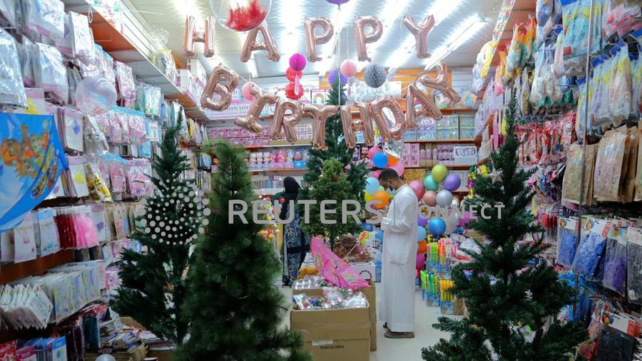 A woman wearing a mask to protect from the coronavirus leaves a gift shop decorated for Christmas and New Year in Jiddah, Saudi Arabia, Friday, Dec. 25, 2020. (AP Photo/Amr Nabil)