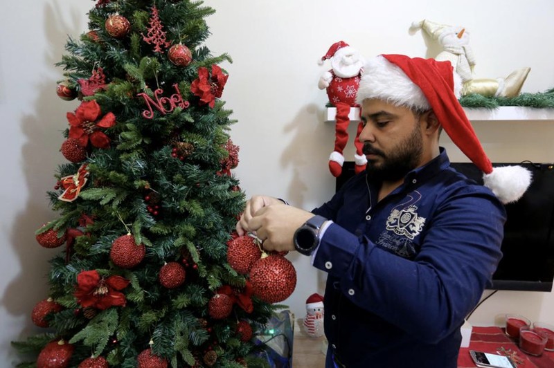 A woman wearing a mask to protect from the coronavirus leaves a gift shop decorated for Christmas and New Year in Jiddah, Saudi Arabia, Friday, Dec. 25, 2020. (AP Photo/Amr Nabil)