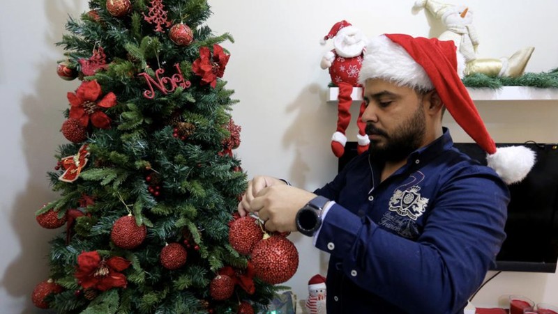 A woman wearing a mask to protect from the coronavirus leaves a gift shop decorated for Christmas and New Year in Jiddah, Saudi Arabia, Friday, Dec. 25, 2020. (AP Photo/Amr Nabil)
