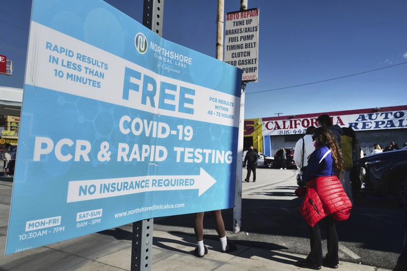 People line up for a free COVID-19 rapid test at a gas station in the Reseda section of Los Angeles on Sunday, Dec. 26, 2021, as California braces for a post-holiday virus surge. (AP Photo/Richard Vogel)