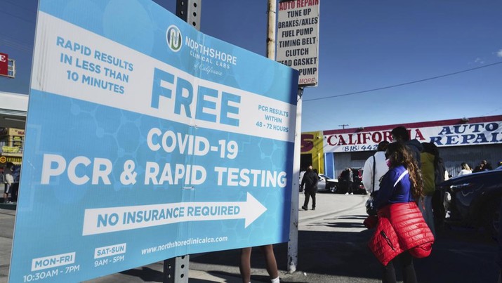 People line up for a free COVID-19 rapid test at a gas station in the Reseda section of Los Angeles on Sunday, Dec. 26, 2021, as California braces for a post-holiday virus surge. (AP Photo/Richard Vogel)