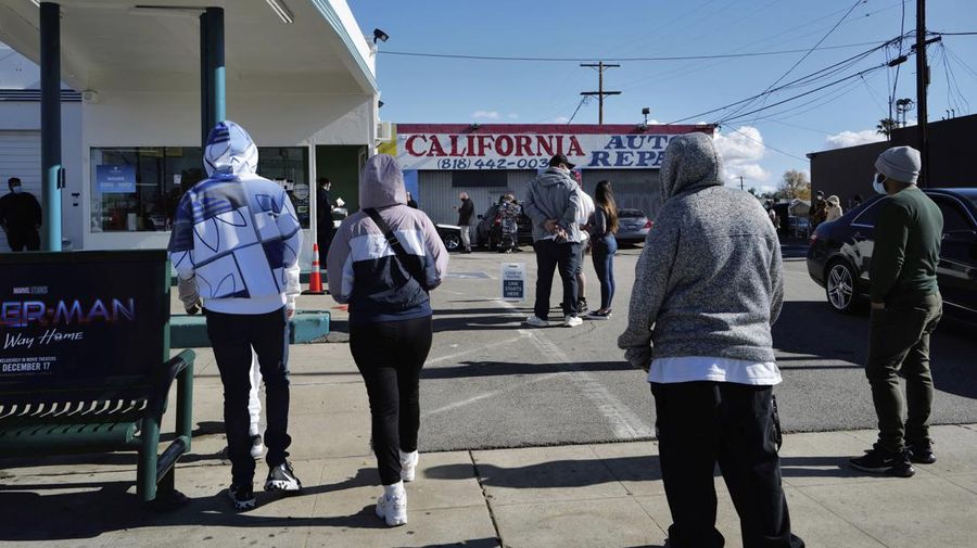 People line up for a free COVID-19 rapid test at a gas station in the Reseda section of Los Angeles on Sunday, Dec. 26, 2021, as California braces for a post-holiday virus surge. (AP Photo/Richard Vogel)