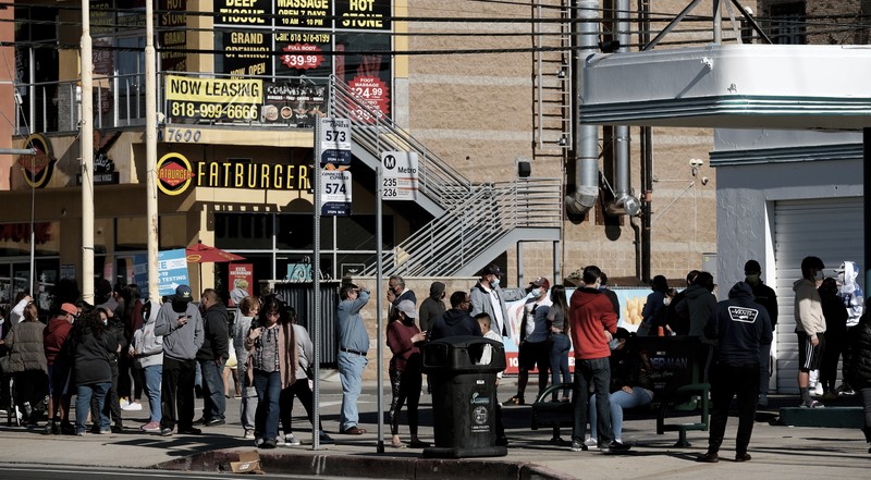 People line up for a free COVID-19 rapid test at a gas station in the Reseda section of Los Angeles on Sunday, Dec. 26, 2021, as California braces for a post-holiday virus surge. (AP Photo/Richard Vogel)