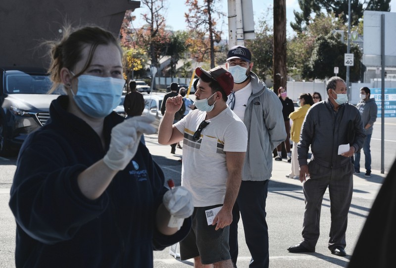 People line up for a free COVID-19 rapid test at a gas station in the Reseda section of Los Angeles on Sunday, Dec. 26, 2021, as California braces for a post-holiday virus surge. (AP Photo/Richard Vogel)
