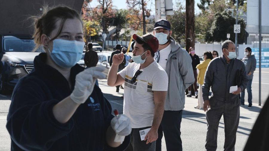 People line up for a free COVID-19 rapid test at a gas station in the Reseda section of Los Angeles on Sunday, Dec. 26, 2021, as California braces for a post-holiday virus surge. (AP Photo/Richard Vogel)
