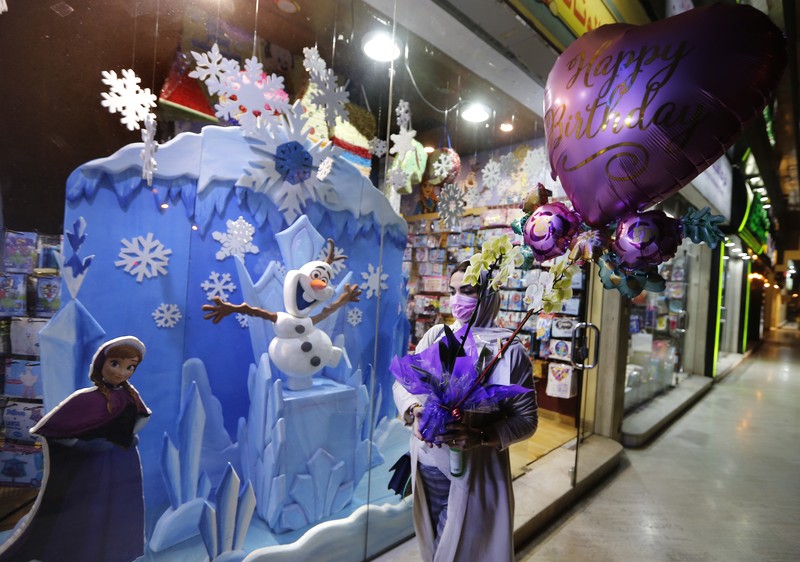 Virus Outbreak Saudi Christmas A woman wearing a mask to protect from the coronavirus leaves a gift shop decorated for Christmas and New Year in Jiddah, Saudi Arabia, Friday, Dec. 25, 2020. (AP Photo/Amr Nabil)