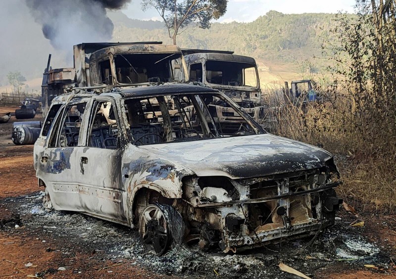 In this photo provided by the Karenni Nationalities Defense Force (KNDF), smokes and flames billow from vehicles in Hpruso township, Kayah state, Myanmar, Friday, Dec. 24, 2021. Myanmar government troops rounded up villagers, some believed to be women and children, fatally shot more than 30 and set the bodies on fire, a witness and other reports said Saturday. (KNDF via AP)