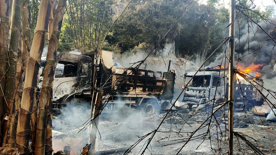 In this photo provided by the Karenni Nationalities Defense Force (KNDF), smokes and flames billow from vehicles in Hpruso township, Kayah state, Myanmar, Friday, Dec. 24, 2021. Myanmar government troops rounded up villagers, some believed to be women and children, fatally shot more than 30 and set the bodies on fire, a witness and other reports said Saturday. (KNDF via AP)