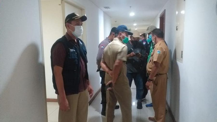 Petugas mencoba memaksa pasien Omicron yang tidak mau di karantina dan tetap menetap di apartmenya (Ist)
