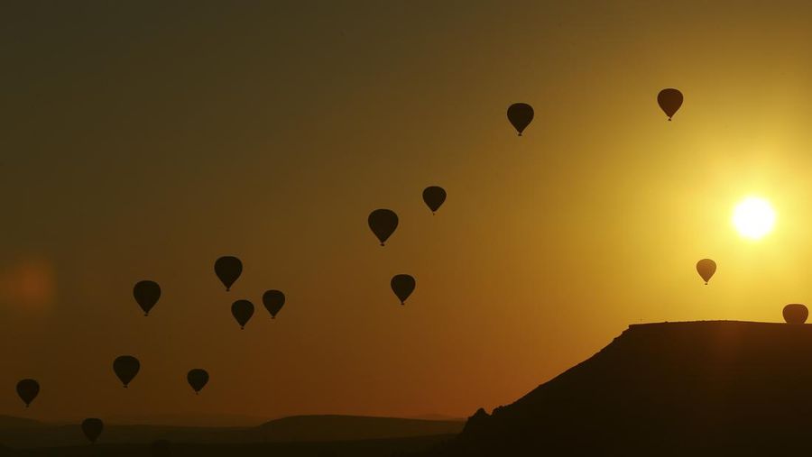 Hot air balloons, carrying tourists, rise into the sky at sunrise in Cappadocia, central Turkey, early Tuesday, Aug. 7, 2018. Cappadocia has become a favourite site for tourists in hot-air balloons who can slowly drift above the cone-shaped rock formations and then float up over rippled ravines for breathtaking views over the region.(AP Photo/Emrah Gurel)