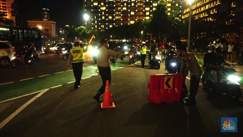 Pemberlakukan Crowd Free Night pada saat malam pergantian tahun 2022 Personel Kepolisian berjaga di kawasan Bundaran HI, Jakarta, Jumat (31/12/2021). Kabid Humas Polda Metro Jaya, Kombes Pol Endra Zulpan menerangkan, 1.730 personel disebar ke beberapa titik terutama di ruas jalan yang akan diberlakukan Crowd Free Night pada saat malam pergantian tahun 2022. Kegiatan yang bertujuan untuk mengurangi volume kendaraan pada malam tahun baru itu berlaku pada 31 Desember 2021 sejak pukul 22.00 WIB sampai 1 Januari 2022 pukul 04.00 WIB di 11 ruas jalan di DKI Jakarta. Petugas Satpol PP berusaha membubarkan warga yang masih berada di lokasi kawasan bundaran Hotel Indonesia. (CNBC Indonesia/ Tri Susilo)
