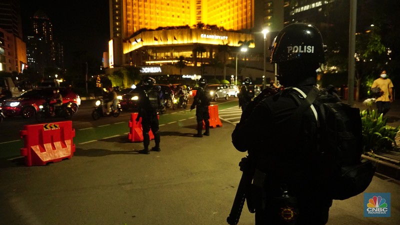 Pemberlakukan Crowd Free Night pada saat malam pergantian tahun 2022 Personel Kepolisian berjaga di kawasan Bundaran HI, Jakarta, Jumat (31/12/2021). Kabid Humas Polda Metro Jaya, Kombes Pol Endra Zulpan menerangkan, 1.730 personel disebar ke beberapa titik terutama di ruas jalan yang akan diberlakukan Crowd Free Night pada saat malam pergantian tahun 2022. Kegiatan yang bertujuan untuk mengurangi volume kendaraan pada malam tahun baru itu berlaku pada 31 Desember 2021 sejak pukul 22.00 WIB sampai 1 Januari 2022 pukul 04.00 WIB di 11 ruas jalan di DKI Jakarta. Petugas Satpol PP berusaha membubarkan warga yang masih berada di lokasi kawasan bundaran Hotel Indonesia. (CNBC Indonesia/ Tri Susilo)