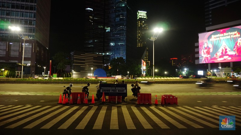 Pemberlakukan Crowd Free Night pada saat malam pergantian tahun 2022 Personel Kepolisian berjaga di kawasan Bundaran HI, Jakarta, Jumat (31/12/2021). Kabid Humas Polda Metro Jaya, Kombes Pol Endra Zulpan menerangkan, 1.730 personel disebar ke beberapa titik terutama di ruas jalan yang akan diberlakukan Crowd Free Night pada saat malam pergantian tahun 2022. Kegiatan yang bertujuan untuk mengurangi volume kendaraan pada malam tahun baru itu berlaku pada 31 Desember 2021 sejak pukul 22.00 WIB sampai 1 Januari 2022 pukul 04.00 WIB di 11 ruas jalan di DKI Jakarta. Petugas Satpol PP berusaha membubarkan warga yang masih berada di lokasi kawasan bundaran Hotel Indonesia. (CNBC Indonesia/ Tri Susilo)