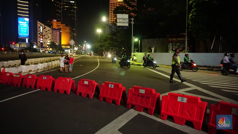 Pemberlakukan Crowd Free Night pada saat malam pergantian tahun 2022 Personel Kepolisian berjaga di kawasan Bundaran HI, Jakarta, Jumat (31/12/2021). Kabid Humas Polda Metro Jaya, Kombes Pol Endra Zulpan menerangkan, 1.730 personel disebar ke beberapa titik terutama di ruas jalan yang akan diberlakukan Crowd Free Night pada saat malam pergantian tahun 2022. Kegiatan yang bertujuan untuk mengurangi volume kendaraan pada malam tahun baru itu berlaku pada 31 Desember 2021 sejak pukul 22.00 WIB sampai 1 Januari 2022 pukul 04.00 WIB di 11 ruas jalan di DKI Jakarta. Petugas Satpol PP berusaha membubarkan warga yang masih berada di lokasi kawasan bundaran Hotel Indonesia. (CNBC Indonesia/ Tri Susilo)