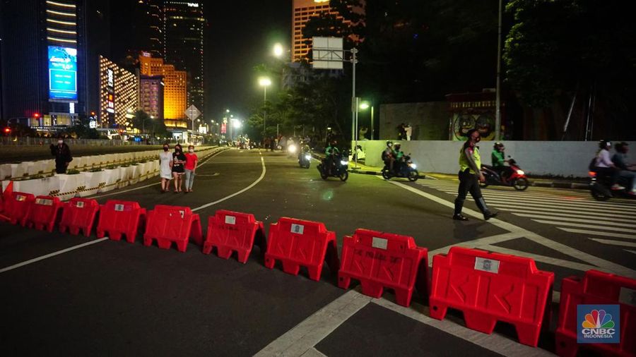 Personel Kepolisian berjaga di kawasan Bundaran HI, Jakarta, Jumat (31/12/2021). Kabid Humas Polda Metro Jaya, Kombes Pol Endra Zulpan menerangkan, 1.730 personel disebar ke beberapa titik terutama di ruas jalan yang akan diberlakukan Crowd Free Night pada saat malam pergantian tahun 2022. Kegiatan yang  bertujuan untuk mengurangi volume kendaraan pada malam tahun baru itu berlaku pada 31 Desember 2021 sejak pukul 22.00 WIB sampai 1 Januari 2022 pukul 04.00 WIB di 11 ruas jalan di DKI Jakarta. Petugas Satpol PP berusaha membubarkan warga yang masih berada di lokasi kawasan bundaran Hotel Indonesia. (CNBC Indonesia/ Tri Susilo)