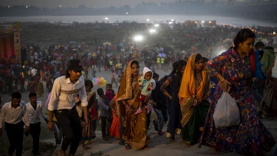 Umat Hindu pergi setelah melakukan ritual di tepi sungai Yamuna di New Delhi, India, pada 10 November 2021, selama festival Chhath Puja, yang diadakan untuk berterima kasih kepada dewa matahari karena telah menopang kehidupan di bumi. (AP Photo/Altaf Qadri)