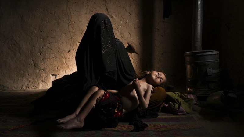 Hamid Abdullah berdiri di luar ruangan tempat anak-anaknya bermain di sebuah pemukiman dekat Herat, Afghanistan (16/12/2021). Abdullah menjual putrinya yang masih kecil untuk dijodohkan karena sangat membutuhkan uang untuk mengobati istrinya yang sakit kronis dan hamil anak kelima mereka . (AP/Mstyslav Chernov)