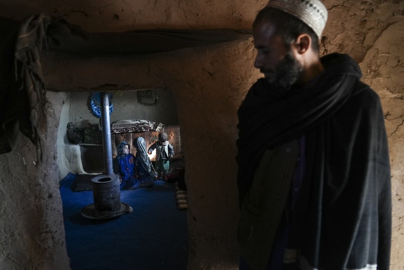 Hamid Abdullah berdiri di luar ruangan tempat anak-anaknya bermain di sebuah pemukiman dekat Herat, Afghanistan (16/12/2021). Abdullah menjual putrinya yang masih kecil untuk dijodohkan karena sangat membutuhkan uang untuk mengobati istrinya yang sakit kronis dan hamil anak kelima mereka . (AP/Mstyslav Chernov)