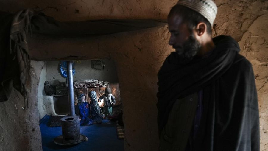 Hamid Abdullah berdiri di luar ruangan tempat anak-anaknya bermain di sebuah pemukiman dekat Herat, Afghanistan (16/12/2021). Abdullah menjual putrinya yang masih kecil untuk dijodohkan karena sangat membutuhkan uang untuk mengobati istrinya yang sakit kronis dan hamil anak kelima mereka . (AP/Mstyslav Chernov)