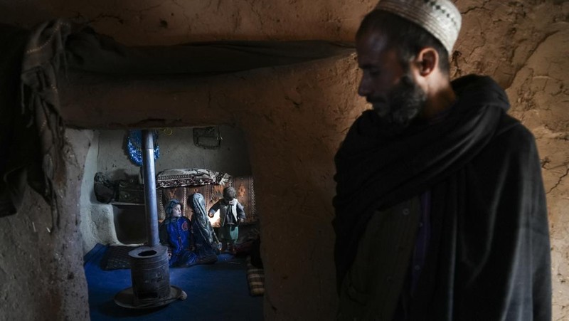 Hamid Abdullah berdiri di luar ruangan tempat anak-anaknya bermain di sebuah pemukiman dekat Herat, Afghanistan (16/12/2021). Abdullah menjual putrinya yang masih kecil untuk dijodohkan karena sangat membutuhkan uang untuk mengobati istrinya yang sakit kronis dan hamil anak kelima mereka . (AP/Mstyslav Chernov)