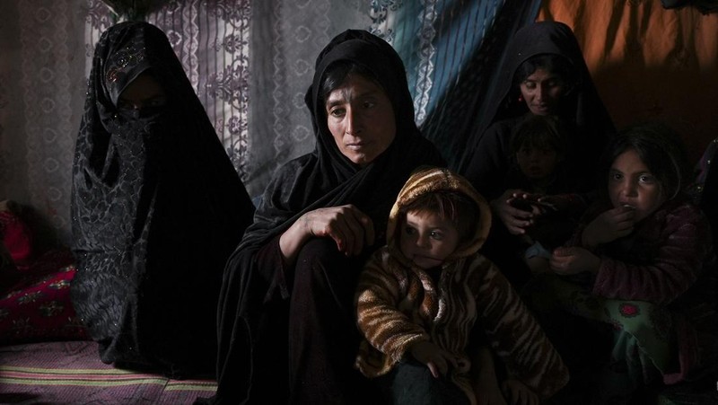 Hamid Abdullah berdiri di luar ruangan tempat anak-anaknya bermain di sebuah pemukiman dekat Herat, Afghanistan (16/12/2021). Abdullah menjual putrinya yang masih kecil untuk dijodohkan karena sangat membutuhkan uang untuk mengobati istrinya yang sakit kronis dan hamil anak kelima mereka . (AP/Mstyslav Chernov)