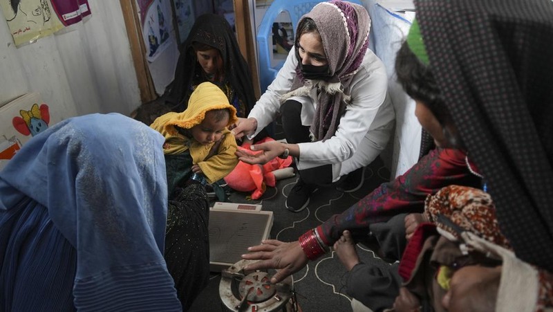 Hamid Abdullah berdiri di luar ruangan tempat anak-anaknya bermain di sebuah pemukiman dekat Herat, Afghanistan (16/12/2021). Abdullah menjual putrinya yang masih kecil untuk dijodohkan karena sangat membutuhkan uang untuk mengobati istrinya yang sakit kronis dan hamil anak kelima mereka . (AP/Mstyslav Chernov)