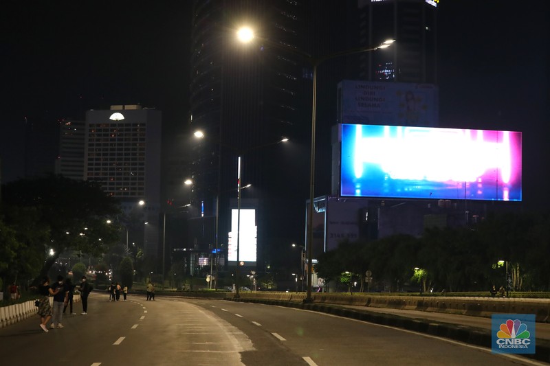 Suasana kawasan Sudirman - Thamrin saat pemberlakuan crowd free night (CFN) Seorang pedang kopi keliling melewati ruas jalan utama di kawasan jalan Sudirman-Thamrin, Jakarta, Sabtu (1/1/2022). Sejak pukul 22.00 WIB terpantau kendaraan dan warga sangat lengang.
Kendaraan operasional polisi tampak menyusuri ruas-ruas jalan yang menjadi titik penutupan jalan.Malam pergantian tahun 2021 menuju 2022 di pusat Kota Jakarta berlangsung sepi. Pemerintah Provinsi DKI Jakarta bersama Polda Metro Jaya menutup 11 ruas jalan sejak pukul 22.00 WIB.
Dari pantauan dilokasi sejumlah ruas jalan di Jakarta terpantau lengang. Tak banyak kendaraan melintas.
Kendaraan operasional polisi tampak menyusuri ruas-ruas jalan yang menjadi titik penutupan jalan (CNBC Indonesia/ Tri Susilo)