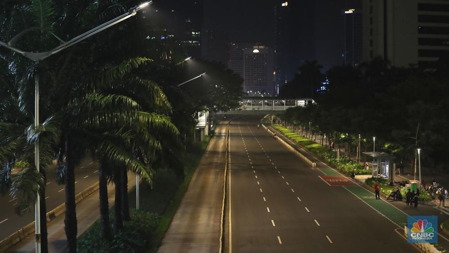 Seorang pedang kopi keliling melewati ruas jalan utama di kawasan jalan Sudirman-Thamrin, Jakarta, Sabtu (1/1/2022). Sejak pukul 22.00 WIB terpantau kendaraan dan warga  sangat lengang. 
Kendaraan operasional polisi tampak menyusuri ruas-ruas jalan yang menjadi titik penutupan jalan.Malam pergantian tahun 2021 menuju 2022 di pusat Kota Jakarta berlangsung sepi. Pemerintah Provinsi DKI Jakarta bersama Polda Metro Jaya menutup 11 ruas jalan sejak pukul 22.00 WIB.
Dari pantauan dilokasi sejumlah ruas jalan di Jakarta terpantau lengang. Tak banyak kendaraan melintas.   
Kendaraan operasional polisi tampak menyusuri ruas-ruas jalan yang menjadi titik penutupan jalan (CNBC Indonesia/ Tri Susilo)